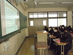 教室でプロジェクターで映された画面を見て講習を受ける生徒の画像