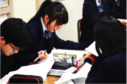 書いた小論文を友人と共有する生徒の画像