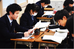 友人の小論文を熟読する生徒の画像