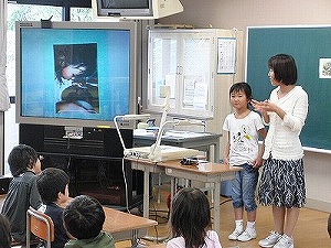 お手伝いの様子を実物投影機を使って発表する様子