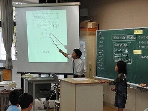 ワークシートにまとめた児童の考えを拡大して表示している場面