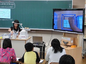 <font size="-1">立体の大きさを確かめるために実物投影機を使っている場面</font>
