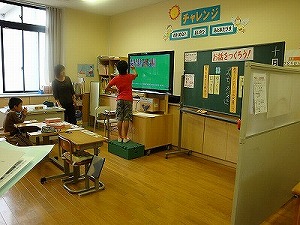 <font size="-1">電子黒板を操作し、絵の順序を入れ替える児童</font>
