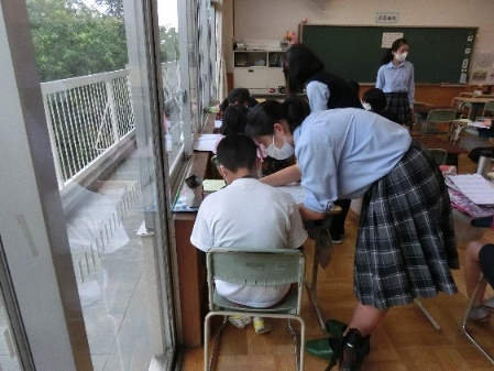 小学校で勉強を教えている生徒の画像