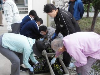 地域の方と一緒に花を植えている生徒の画像